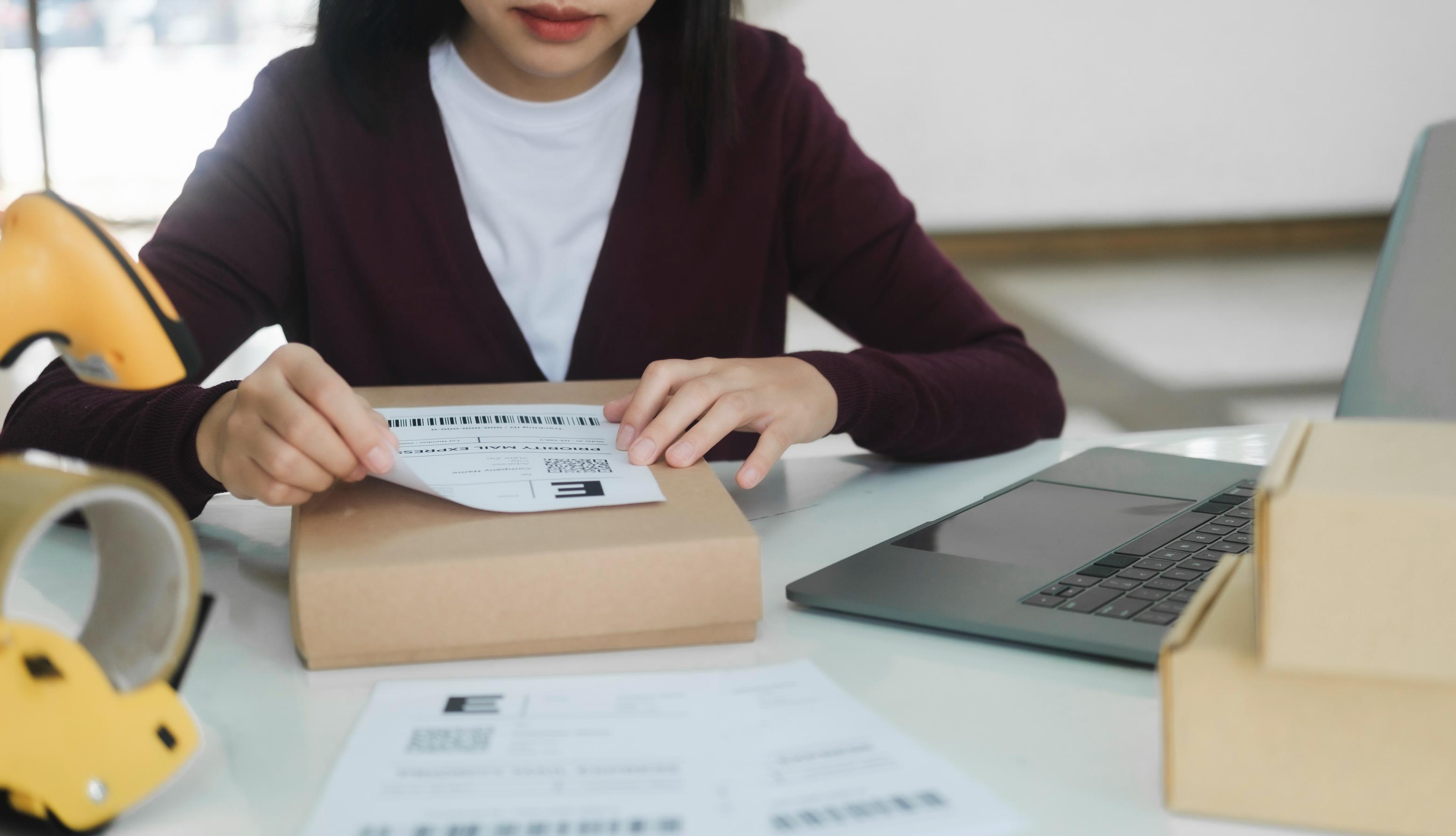 Woman sticking a regular printer label on her package