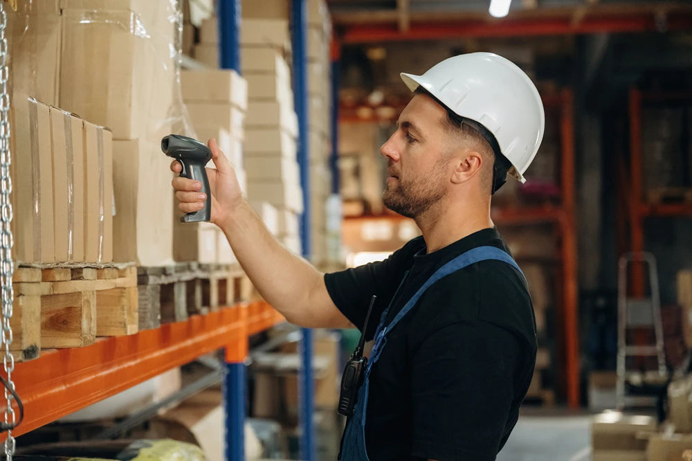 Warehouse worker scanning labelled cartons in a logistics facility